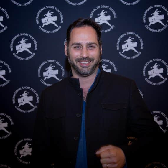 Le cinéaste Wissam Charaf devant le photocall aux couleurs du festival lors de l'édition 2020